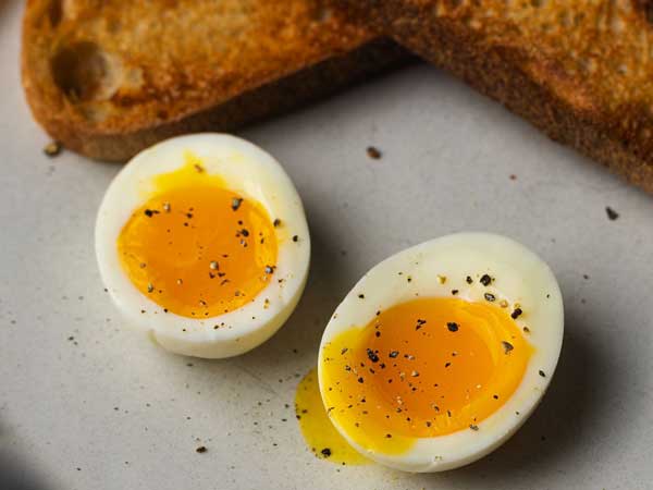 two soft boiled egg halves with a little bit of pepper