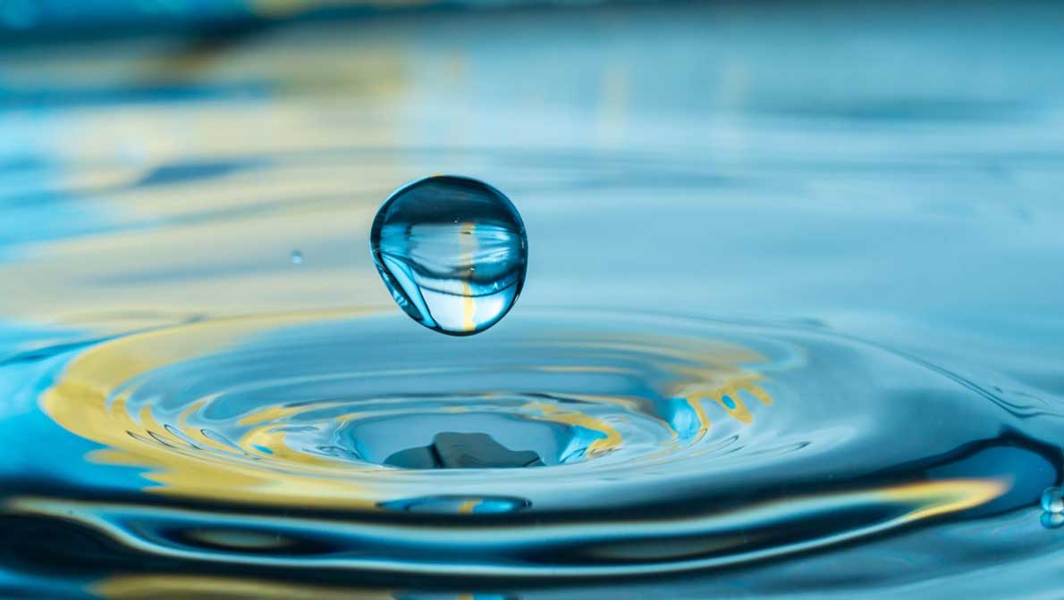 a water drop falling into bigger water